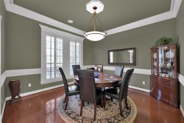 dining area with crown molding, wood finished floors, and baseboards