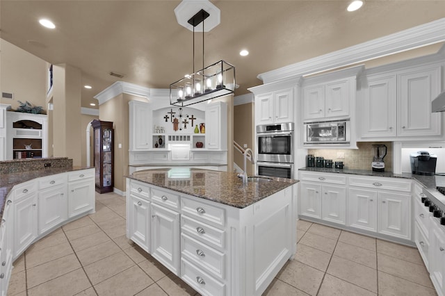 kitchen with tasteful backsplash, open shelves, light tile patterned flooring, stainless steel appliances, and a kitchen island with sink