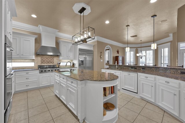 kitchen with light tile patterned flooring, stainless steel appliances, crown molding, and a sink