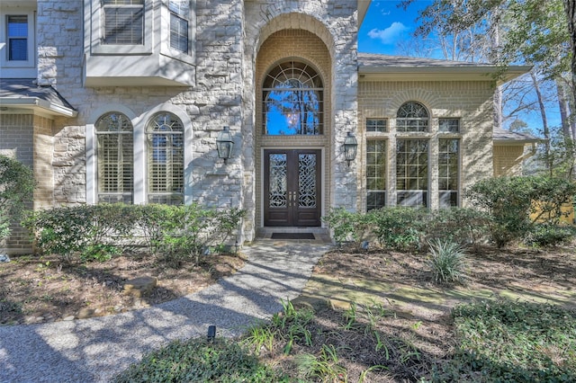 view of exterior entry with brick siding and french doors