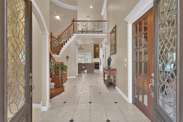 entryway featuring baseboards, stairs, ornamental molding, light tile patterned floors, and french doors