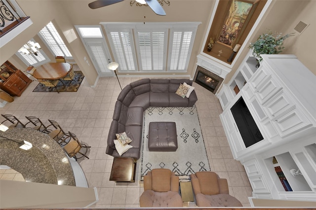 living room with visible vents, plenty of natural light, a glass covered fireplace, and light tile patterned flooring