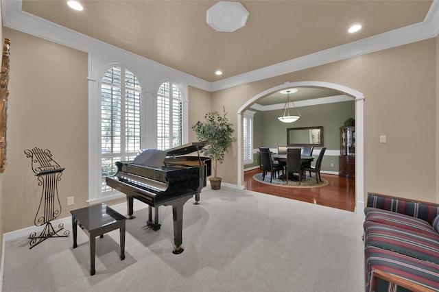 living area with recessed lighting, arched walkways, carpet floors, and crown molding