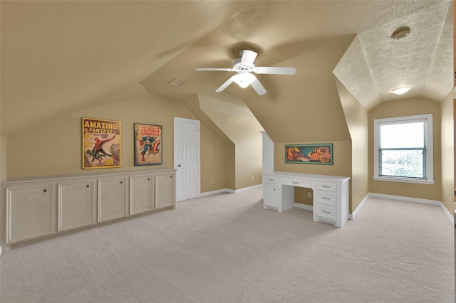 bonus room with light colored carpet, a textured ceiling, baseboards, and vaulted ceiling