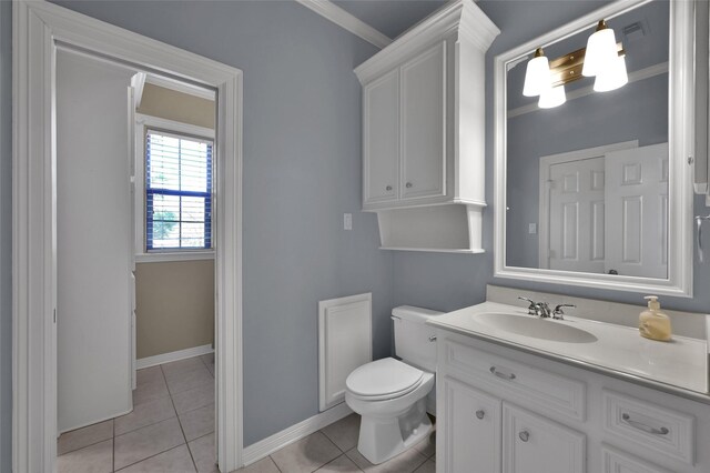 bathroom with vanity, baseboards, crown molding, tile patterned floors, and toilet