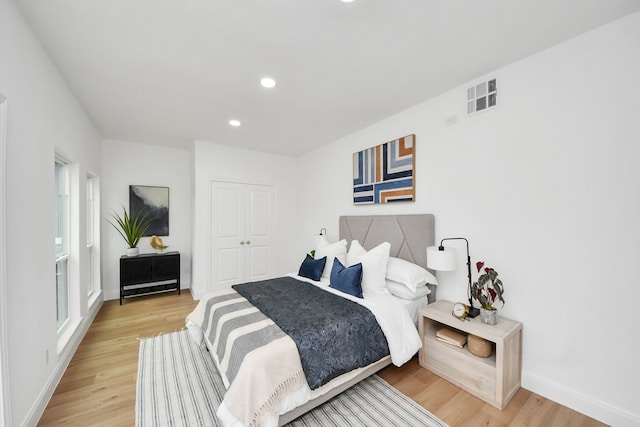 bedroom with visible vents, baseboards, recessed lighting, light wood-style floors, and a closet