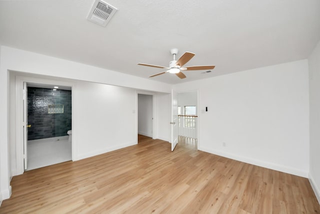 spare room featuring baseboards, a ceiling fan, visible vents, and light wood-type flooring