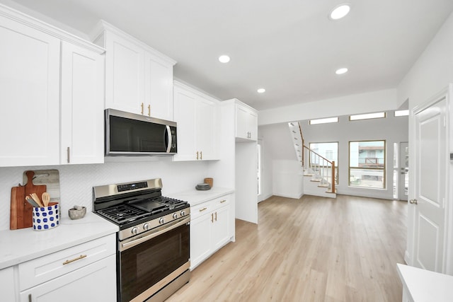 kitchen featuring light wood-style flooring, white cabinets, and stainless steel appliances