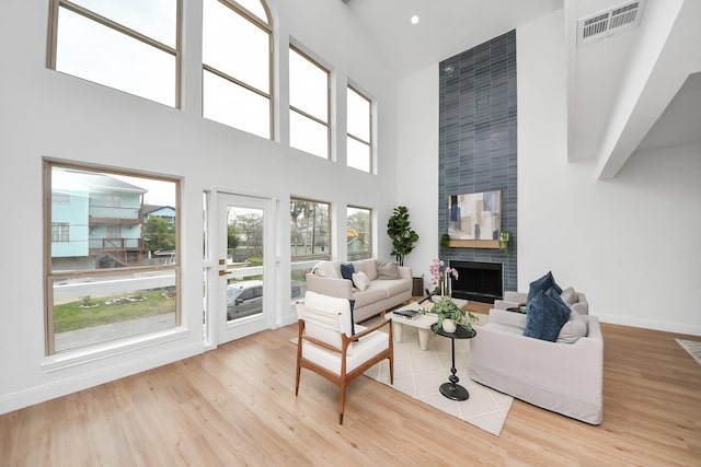 living area featuring visible vents, baseboards, wood finished floors, and a fireplace