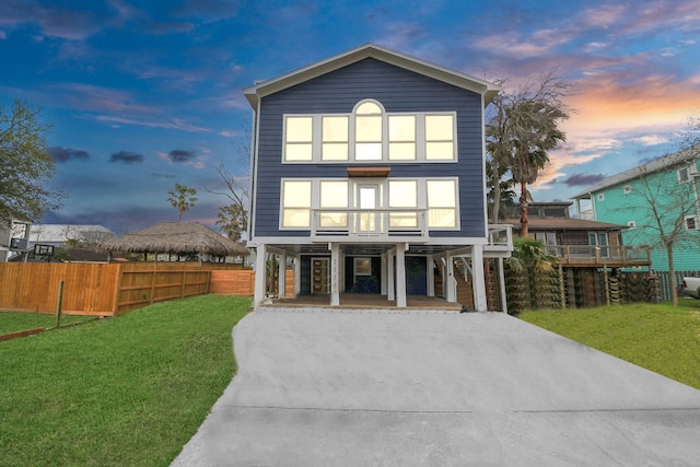 view of front of property with driveway, a carport, a front yard, and fence