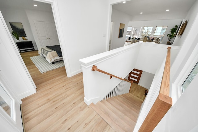 stairs with recessed lighting, baseboards, and wood finished floors