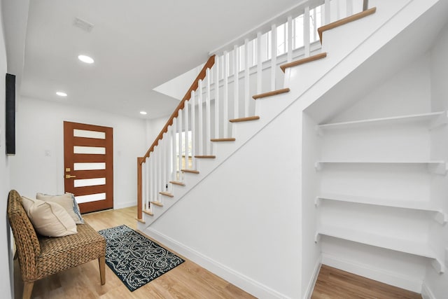 entryway with stairs, recessed lighting, wood finished floors, and baseboards