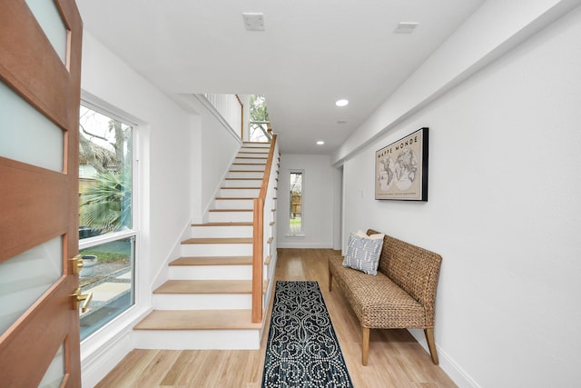 stairway featuring recessed lighting, wood finished floors, and baseboards