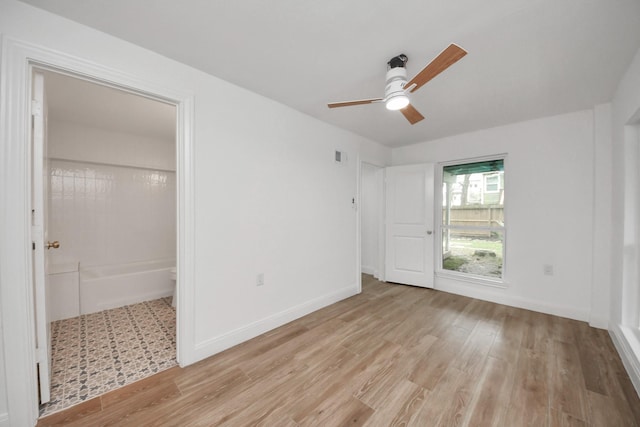 unfurnished bedroom featuring a ceiling fan, light wood-style flooring, visible vents, and baseboards