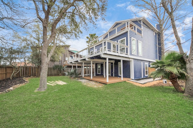 rear view of property featuring a yard, fence, and a wooden deck