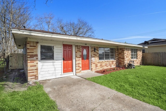 single story home with brick siding, a front lawn, and fence