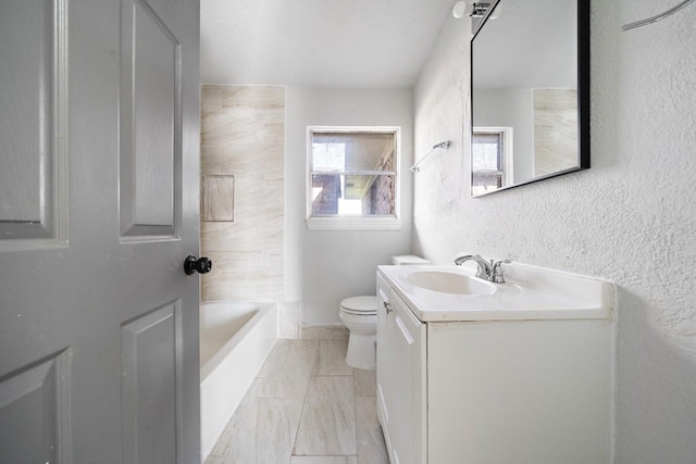 bathroom featuring toilet, vanity, and a textured wall