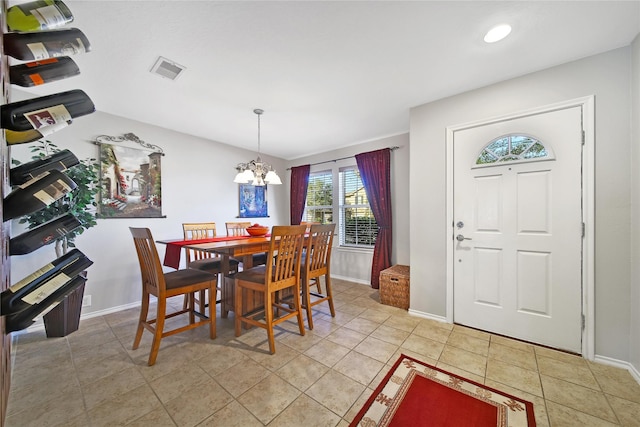 dining space with light tile patterned floors, visible vents, baseboards, and a chandelier