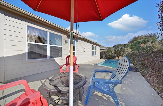 view of patio featuring an outdoor pool and an outdoor fire pit