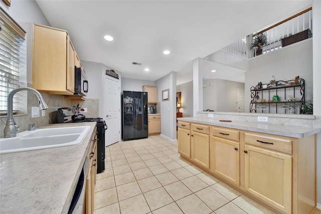 kitchen with light brown cabinets, visible vents, a sink, black appliances, and light countertops