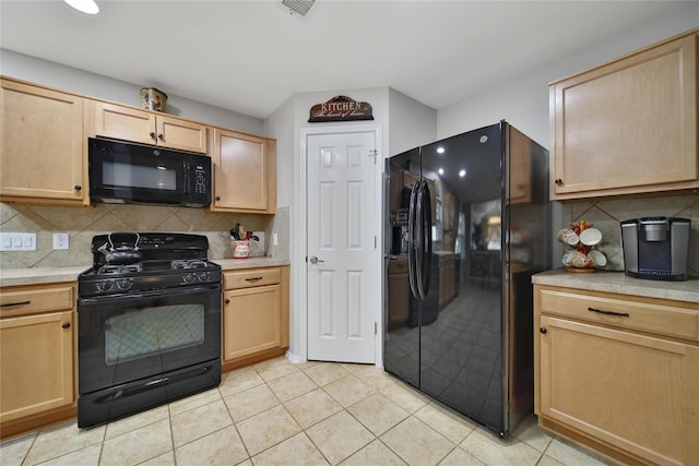 kitchen featuring light tile patterned flooring, light brown cabinets, black appliances, and light countertops