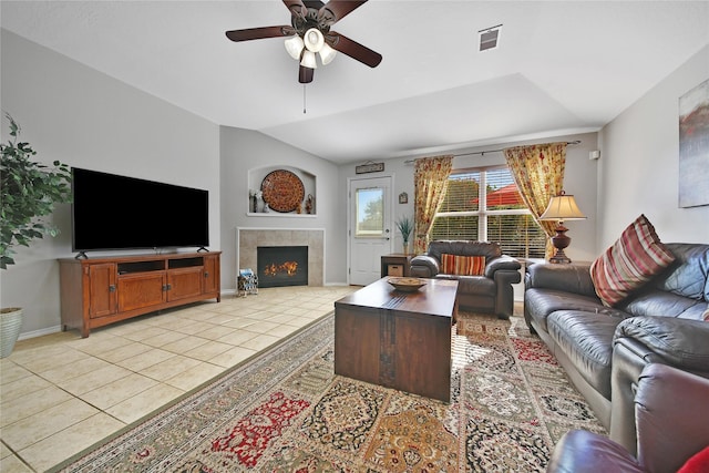 living room featuring visible vents, a tiled fireplace, light tile patterned flooring, baseboards, and ceiling fan