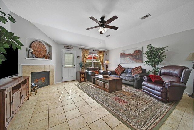 living area with light tile patterned floors, a ceiling fan, visible vents, and a tile fireplace