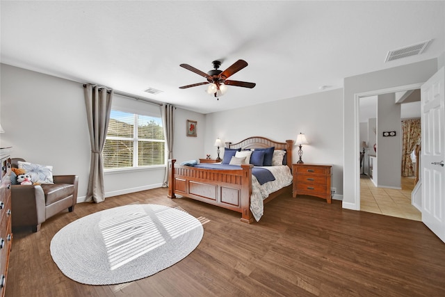 bedroom with visible vents, baseboards, wood finished floors, and a ceiling fan