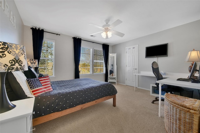 bedroom with visible vents, light colored carpet, baseboards, and ceiling fan