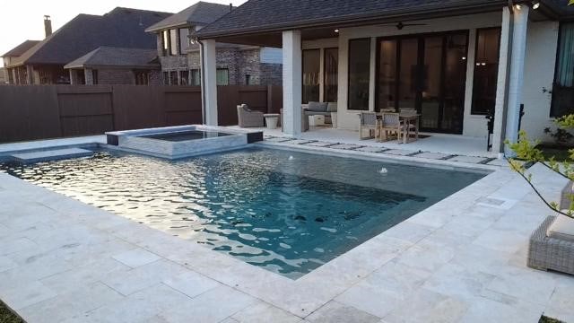 view of swimming pool featuring a patio area, a pool with connected hot tub, and fence