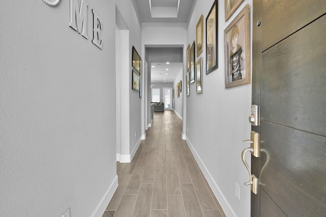 corridor featuring baseboards and wood tiled floor