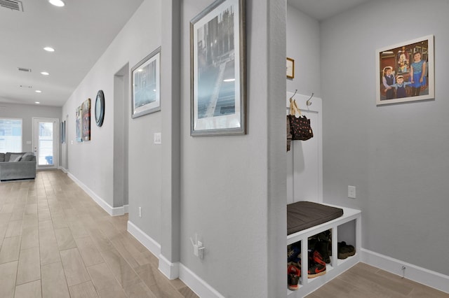 hallway featuring recessed lighting, light wood-style flooring, and baseboards