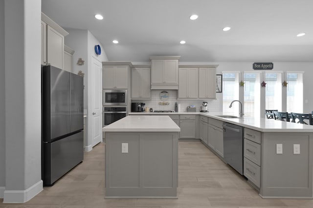 kitchen with backsplash, a center island, appliances with stainless steel finishes, a peninsula, and light countertops