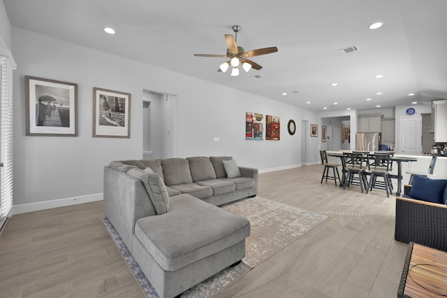 living area with visible vents, recessed lighting, light wood-type flooring, and baseboards