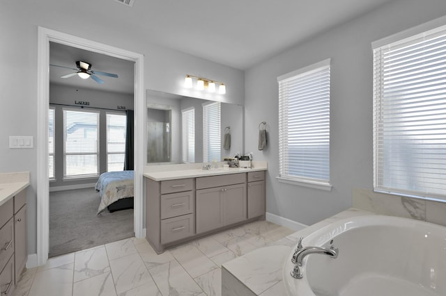 bathroom with baseboards, ensuite bath, a bath, marble finish floor, and vanity