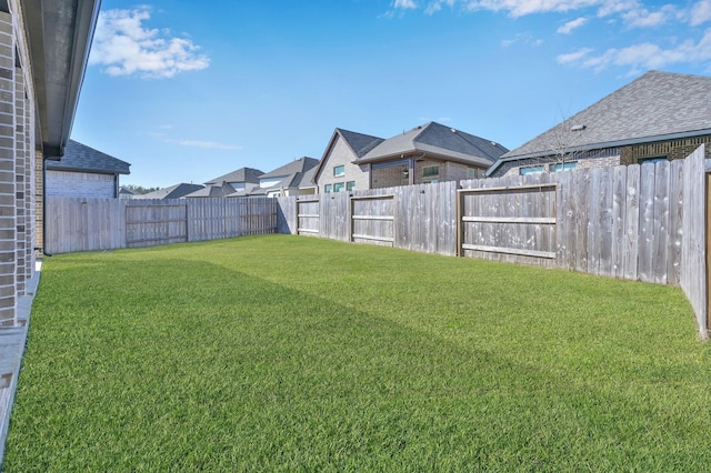 view of yard with a fenced backyard and a residential view