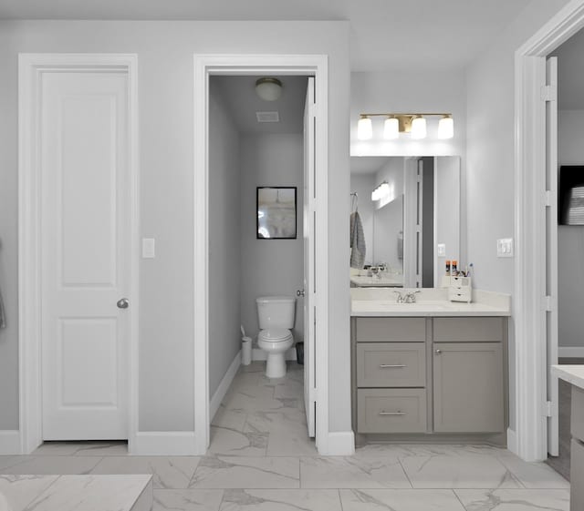 bathroom with vanity, visible vents, baseboards, toilet, and marble finish floor