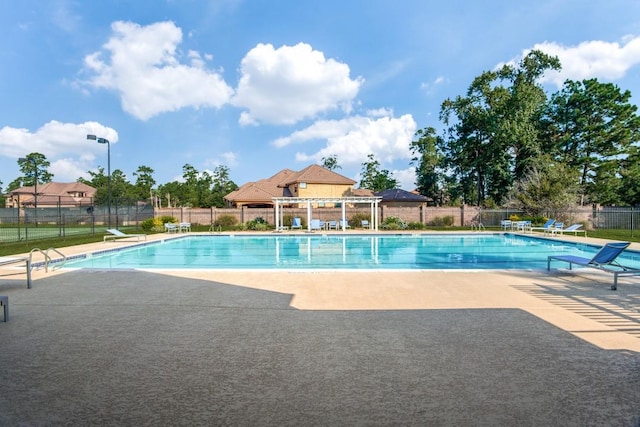 community pool featuring a patio, fence, and a pergola