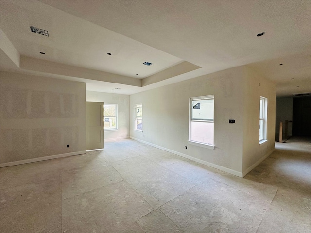 empty room with a raised ceiling and baseboards