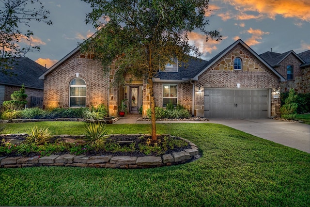 traditional-style house with a front lawn, stone siding, concrete driveway, a garage, and brick siding