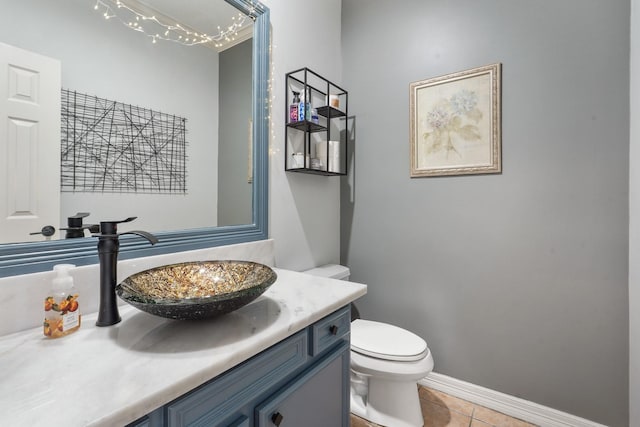 bathroom featuring tile patterned floors, baseboards, toilet, and vanity