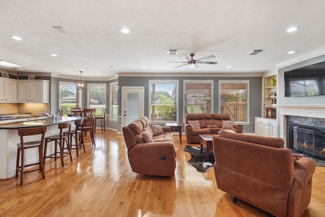 living room with plenty of natural light, a fireplace, and light wood-type flooring