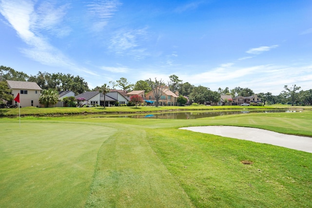 surrounding community with a residential view, a water view, and a lawn