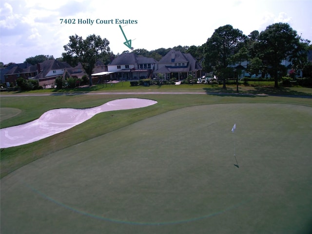 view of home's community featuring golf course view and a lawn