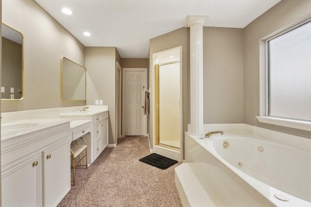 bathroom featuring a jetted tub, decorative columns, double vanity, a stall shower, and a sink