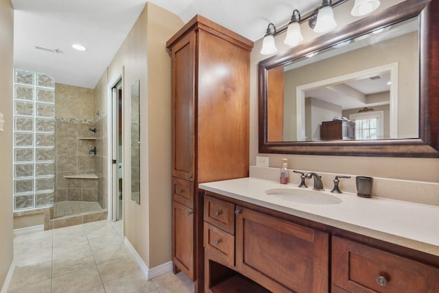 bathroom with tile patterned flooring, baseboards, vanity, and walk in shower