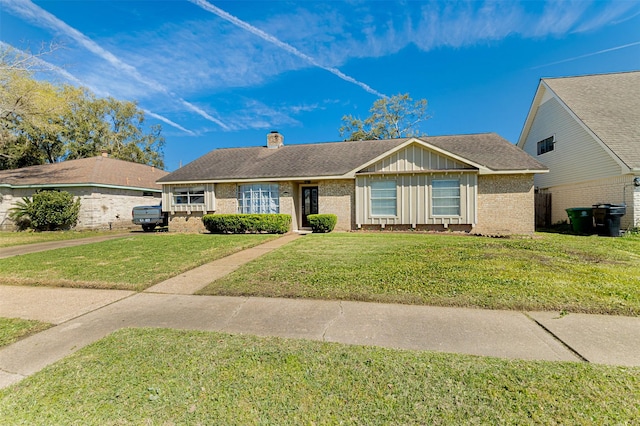 ranch-style house with brick siding, board and batten siding, a chimney, and a front yard