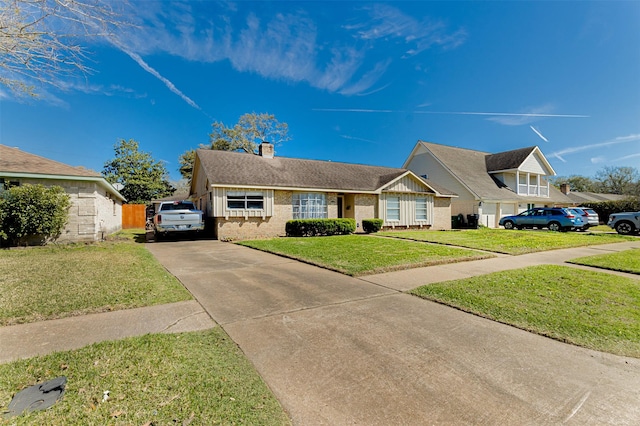 view of front of property with brick siding, concrete driveway, a chimney, and a front lawn