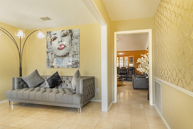 corridor featuring light tile patterned floors, visible vents, and baseboards