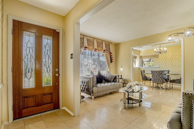 entryway featuring wallpapered walls, a notable chandelier, baseboards, and plenty of natural light